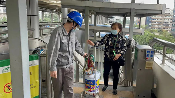 电扶梯大修改造期间，轨道集团维保人员帮助乘客搬运行李