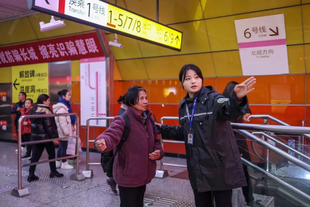 重庆轨道交通1号线换乘站工作人员为乘客服务